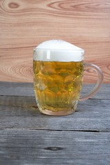 Glass of beer on wooden background