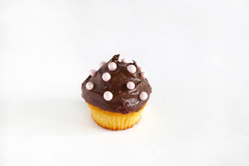 Cupcake with chocolate ganache and pink pearls, isolated