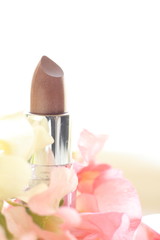 elegant beige color lipstick with sweet pea on background