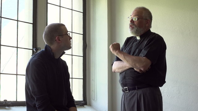 Priest talking with parishioner in a church