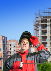  man in working clothes and mask against a new building..