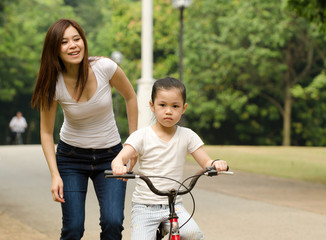 chinese mother having good time on bicycle with her daughter