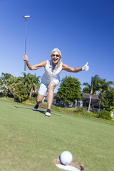 Happy Senior Woman Playing Golf & Putting
