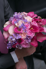 wedding bouquet for bride in hands of groom