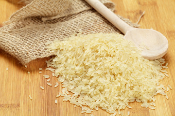 Ungekochter Reis und Holzlöffel