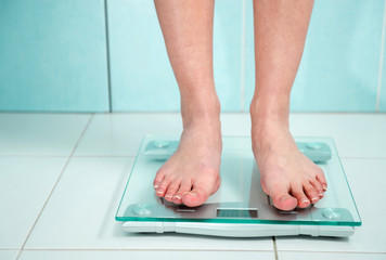 close up of woman feet weighing in bathroom