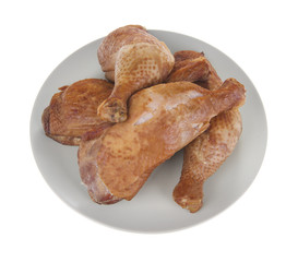 smoked chicken legs in plate, isolated on white