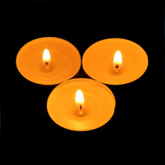 three candles triangle on a black background