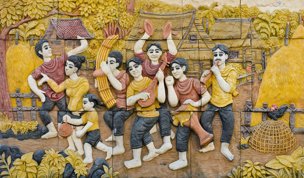 Stone carving of Thai musical instruments on temple wall