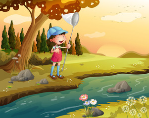 Une fille tenant un filet le long de la rivière