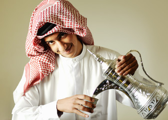 Arabic young man pouring a traditional coffee