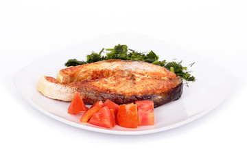 Salmon steak with vegetables on plate. Isolated on white