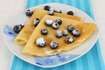 Crepes with blueberries dusted with icing sugar