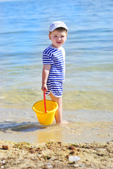 a little boy playing on the sea-shore in summer