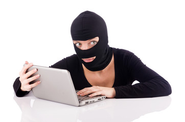 Hacker with computer wearing balaclava