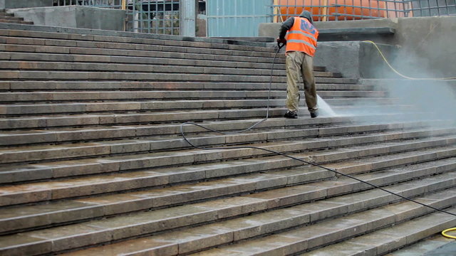 man, a worker cleans the stairs of city services water pressure