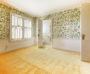 Old American house bedroom with wallpaper and carpet.