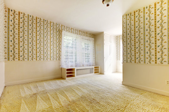 Old American house bedroom with wallpaper and carpet.