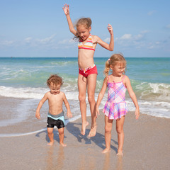 Naklejka premium happy kids playing on beach