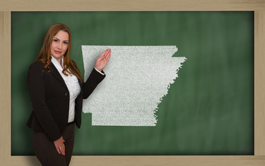 Teacher showing map of arkansas on blackboard