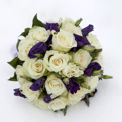 wedding bouquet with rose and lisianthus lying on snow
