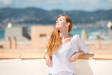Fototapeta na wymiar młoda kobieta, ciesząc się słońcem na tarasie na dachu