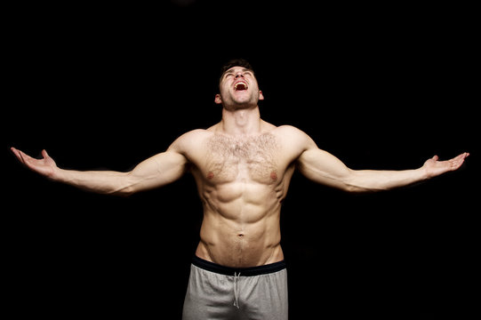 Topless man shouting with his arms outstretched