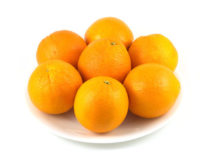 Many oranges on plate isolated over white
