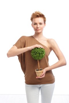 Trendy woman holding potted plant