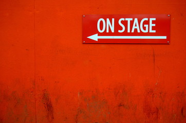 Een grungy & 39 On Stage& 39 -bord buiten een theaterdeur