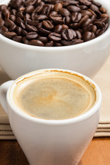 espresso in a cup and cup full of beans
