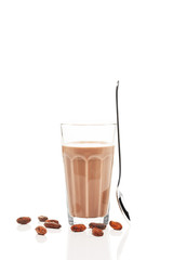 schokoladen milch mit stehendem löffel und schokoladenbohnen