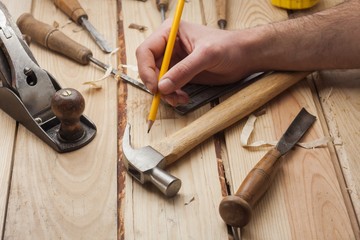 carpenter working,hammer,meter and chisel  over wood table
