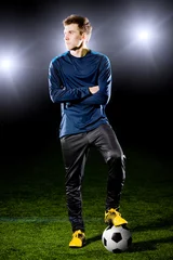 Foto op Plexiglas voetballer op grasveld. Sportief portret. © Alexander Mak