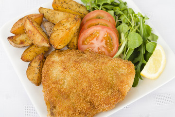Wiener Schnitzel - Breaded fried veal, potato wedges and salad.