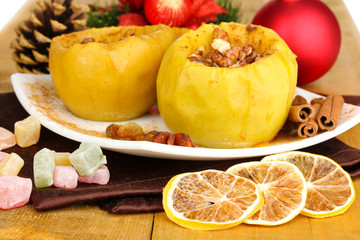 Baked apples on plate on wooden table