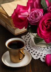 Beautiful pink roses in vase on wooden table close-up