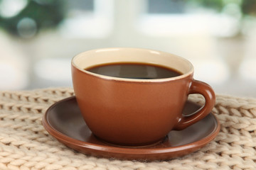 cup of coffee with scarf on table in room