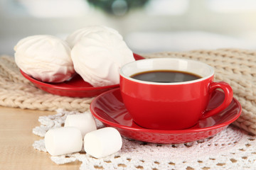 cup of coffee with scarf on table in room