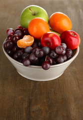 Naklejka na ściany i meble Bowl with fruits, on wooden table