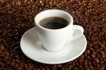 Cup of coffee on coffee beans background