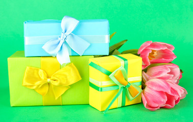 Pink tulips and gift boxes, on color background