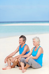 Fototapeta premium Senior Couple In Sports Clothing Relaxing On Beautiful Beach