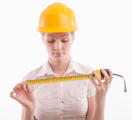 A woman in a helmet with a tape measure