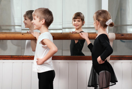 children standing at ballet barre