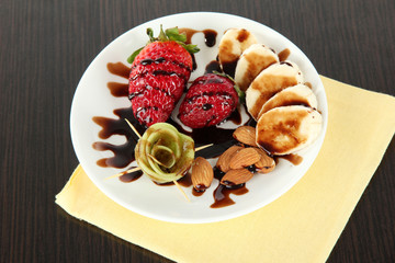 Fruit in chocolate against a dark background