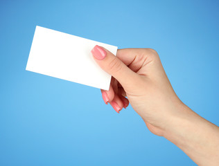 Female hand holding business card, on color background