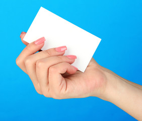 Female hand holding business card, on color background