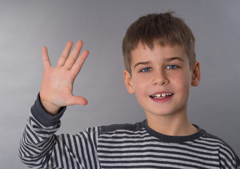 Cute school boy waving his hand