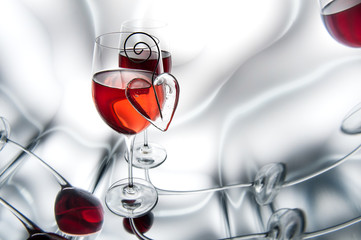 Two glasses of red wine decorated with hearts.